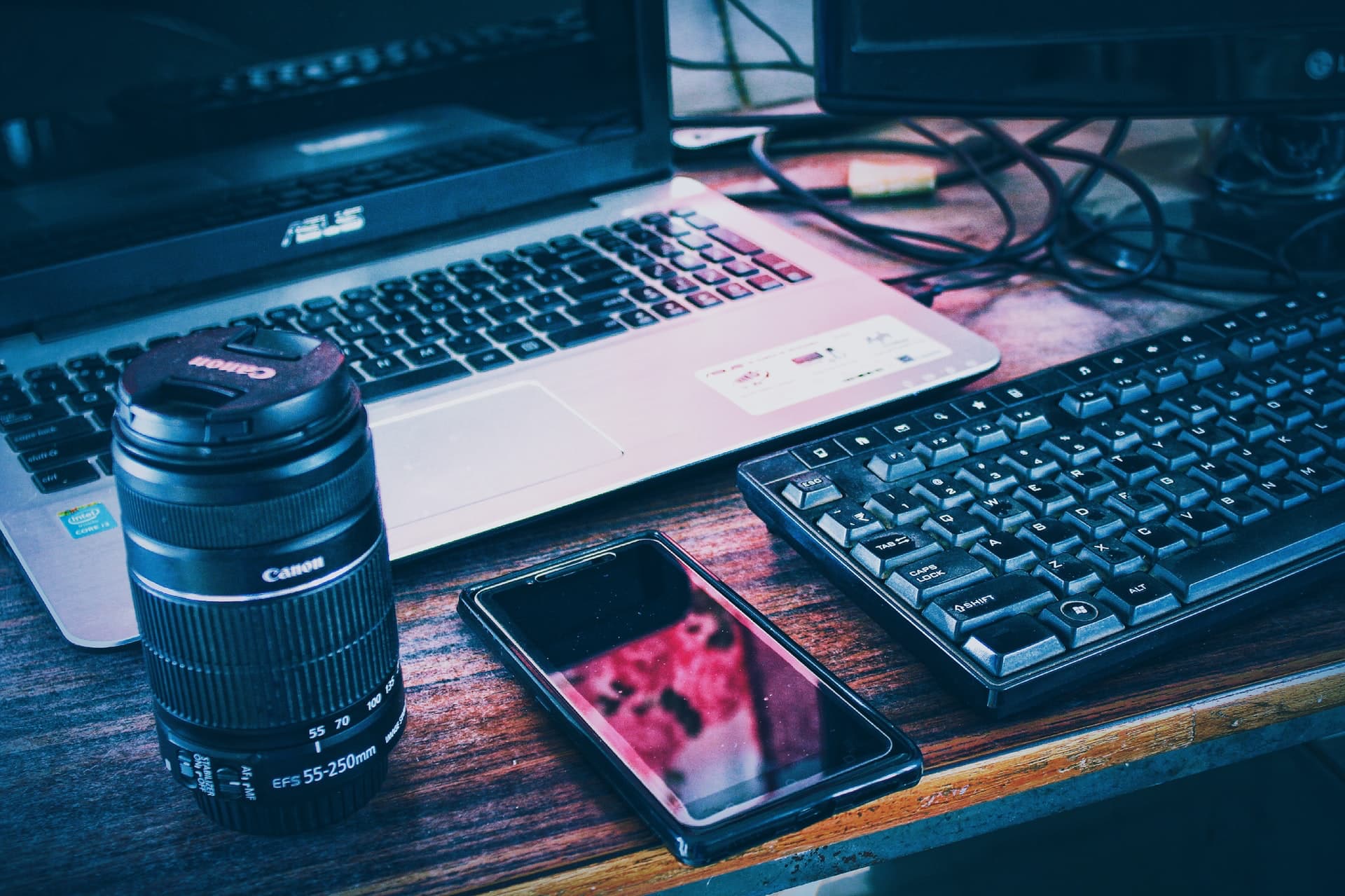 Media photo with devices, laptop, camera lens and keyboard in an artist studio